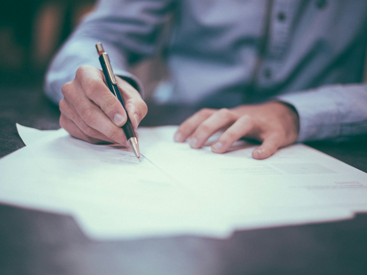 Close-up of a person making careful notes on a printed document.
